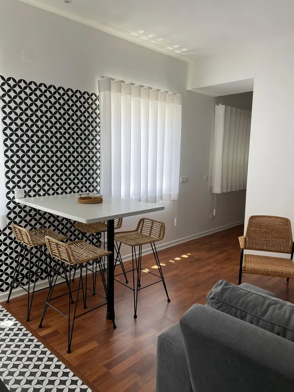 Sala com mesa de refeições e parede de azulejo